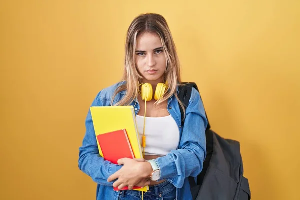学生のバックパックを身に着けている若い金髪の女性は 疲労とハングオーバー 朝の怠惰な目に疲れて眠りと疲れを見ている本を持っています — ストック写真