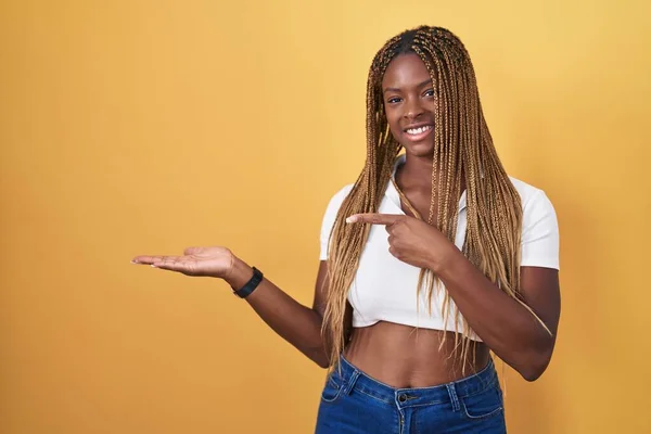 Afroamerikanerin Mit Geflochtenem Haar Steht Erstaunt Vor Gelbem Hintergrund Und — Stockfoto
