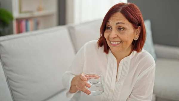 Middelbare Leeftijd Vrouw Drinken Glas Water Zitten Bank Thuis Spreken — Stockfoto