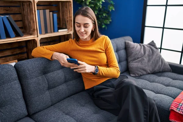 Young Caucasian Woman Using Smartphone Sitting Sofa Home — Stockfoto
