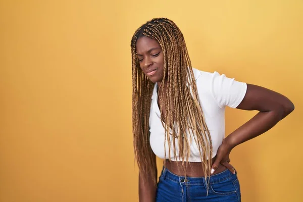 Sarı Arka Planda Dikilen Örülü Saçlı Afrikalı Amerikalı Kadın Sırt — Stok fotoğraf