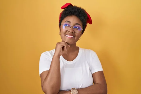 Sarı Arka Planda Pençe Divan Duran Genç Afrikalı Amerikalı Kadın — Stok fotoğraf