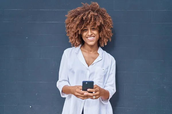 Siyah Arka Planda Akıllı Telefon Kullanarak Gülümseyen Afrikalı Amerikalı Kadın — Stok fotoğraf