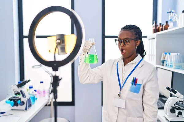 Örgü ören Afrikalı kadın, bilim adamlarının laboratuarında çalışıyor. Akıllı telefonuyla özel ders veriyor. Şaşırtıcı bir şekilde ağzı açık ve korkmuş. 