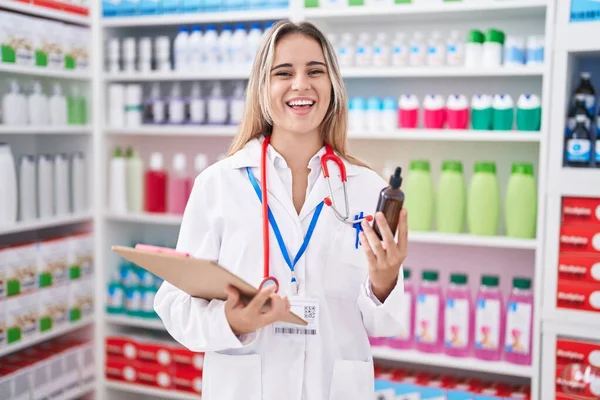 Joven Mujer Rubia Que Trabaja Farmacia Farmacia Sosteniendo Botella Sonriendo — Foto de Stock