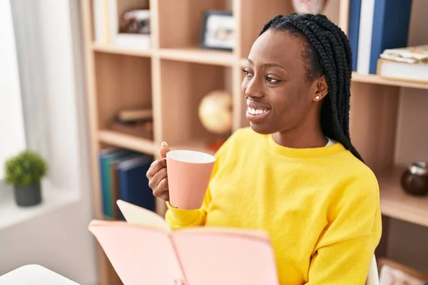 Αφροαμερικανή Γυναίκα Διαβάζει Βιβλίο Και Πίνει Καφέ Στο Σπίτι — Φωτογραφία Αρχείου