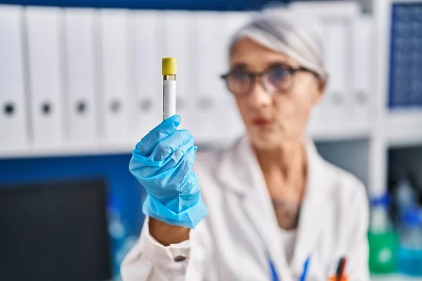 stock image Middle age grey-haired woman scientist holding test tube at laboratory