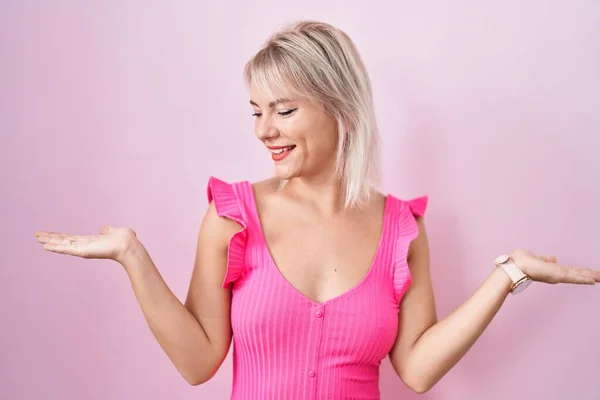 Молода Біла Жінка Стоїть Над Рожевим Тлом Посміхається Показуючи Обидві — стокове фото