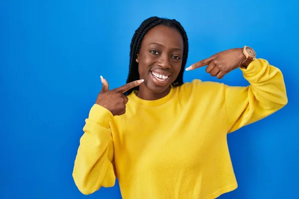 Mooie Zwarte Vrouw Staat Blauwe Achtergrond Lachend Vrolijk Tonen Wijzen — Stockfoto