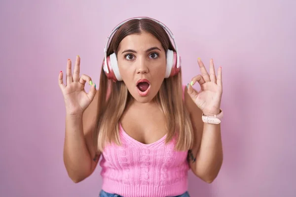 Mujer Rubia Joven Escuchando Música Usando Auriculares Que Parecen Sorprendidos — Foto de Stock
