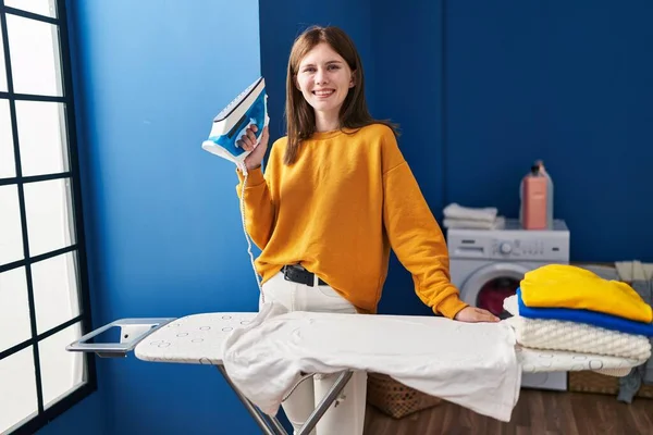 Joven Mujer Rubia Sonriendo Confiada Sosteniendo Máquina Planchar Sala Lavandería —  Fotos de Stock