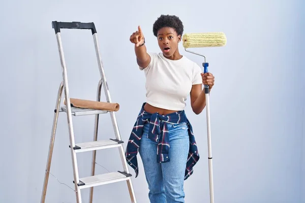 Africano Americano Mulher Segurando Pintor Rolos Apontando Com Dedo Surpreso — Fotografia de Stock