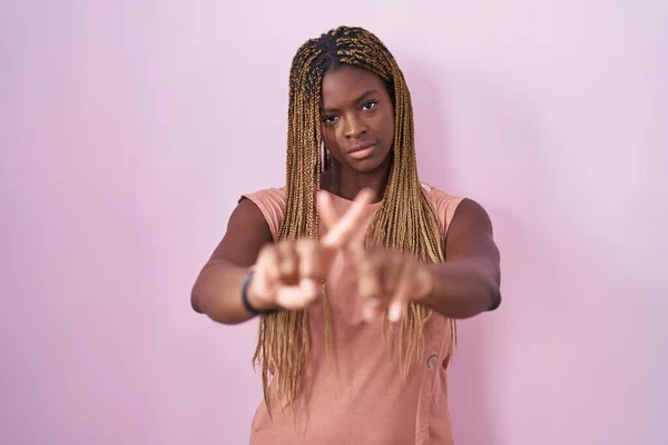 Африканская Американка Плетеными Волосами Стоящая Розовом Фоне Отвергая Выражение Лица — стоковое фото