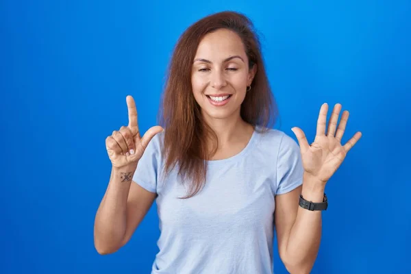 Brunette Woman Standing Blue Background Showing Pointing Fingers Number Seven — Stock Photo, Image