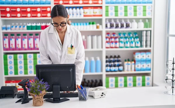 Young Beautiful Hispanic Woman Pharmacist Using Computer Pharmacy — Stockfoto