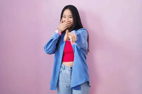 Jonge Aziatische Vrouw Staan Roze Achtergrond Lachen Naar Wijzend Vinger — Stockfoto