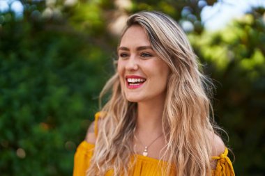 Young woman smiling confident looking to the side at park