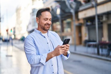 Young caucasian man smiling confident using smartphone at street