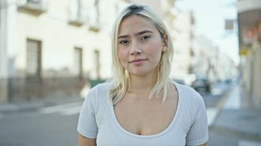 Sokakta ciddi bir ifadeyle duran genç, güzel İspanyol kadın.