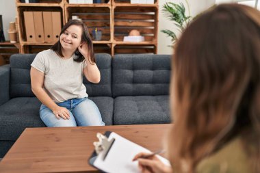 Down sendromlu İspanyol kız terapi yapıyor. Kulaktan kulağa gülüyor. Dedikoduları ve dedikoduları dinliyor. Sağırlık kavramı. 