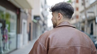 Genç Arap adam caddede geri geri duruyor.