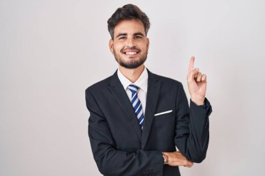 Dövmeli, iş elbiseli, yüzünde kocaman bir gülümseme olan genç İspanyol bir adam kameraya el ile işaret ediyor.. 