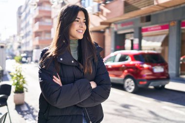 Sokakta kollarını kavuşturmuş genç, güzel İspanyol bir kadın.