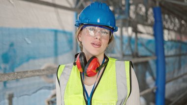 Sarışın genç bir mimar sokakta rahat bir ifadeyle duruyor.