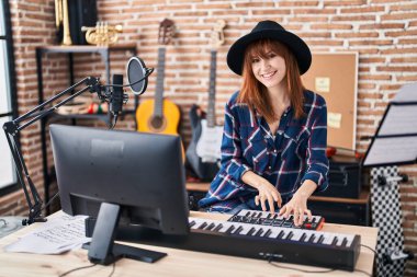 Müzik stüdyosunda piyano çalan genç bir müzisyen kadın.