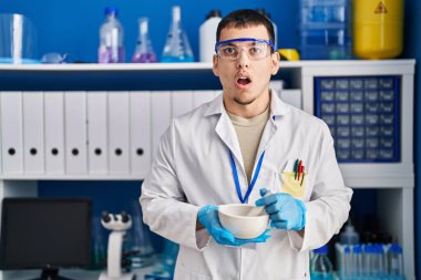 Laboratuvarda çalışan genç Arap adam şaşkınlık ve şaşkınlık ifadesi, korku ve heyecanlı yüz ifadesiyle korkmuş ve şok olmuştu.. 