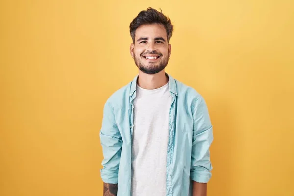 Young Hispanic Man Tattoos Standing Yellow Background Happy Cool Smile — kuvapankkivalokuva