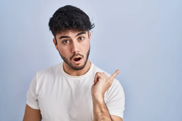 Hispanic Man Beard Standing White Background Surprised Pointing Finger Side — Stockfoto