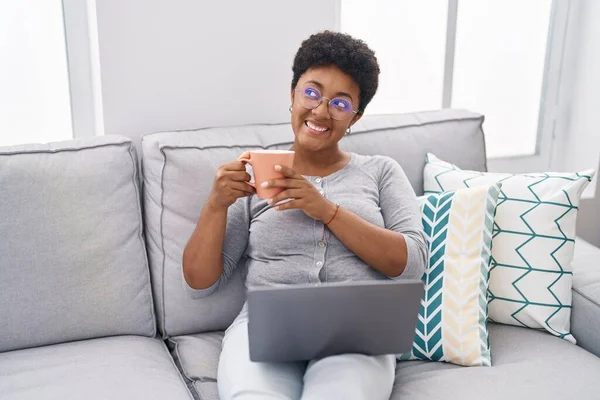 Αφροαμερικανή Γυναίκα Που Χρησιμοποιεί Φορητό Υπολογιστή Και Πίνει Καφέ Καθισμένη — Φωτογραφία Αρχείου
