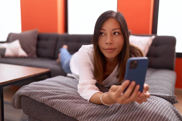 Junge Asiatin Mit Smartphone Hause Auf Sofa Liegend — Stockfoto