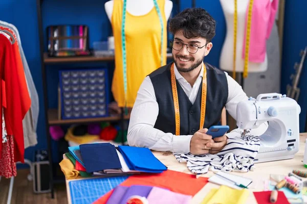 Young Hispanic Man Tailor Smiling Confident Using Smartphone Sewing Studio — Stock Fotó