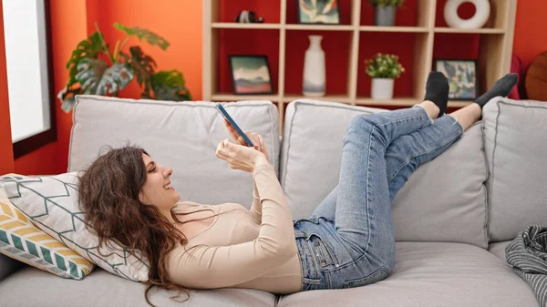Jovem Bela Mulher Hispânica Usando Smartphone Deitado Sofá Casa — Fotografia de Stock