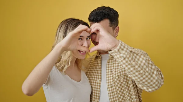 Mann Und Frau Machen Herzensgeste Vor Isoliertem Gelben Hintergrund — Stockfoto