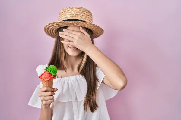 アイスクリームを抱えているティーンエイジャーの少女は笑顔で 驚きのために目を覆う顔で笑います ブラインドコンセプト — ストック写真