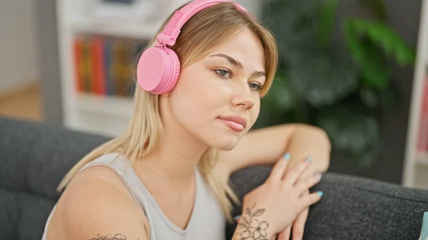 Young Blonde Woman Listening Music Sitting Sofa Home — Stockfoto