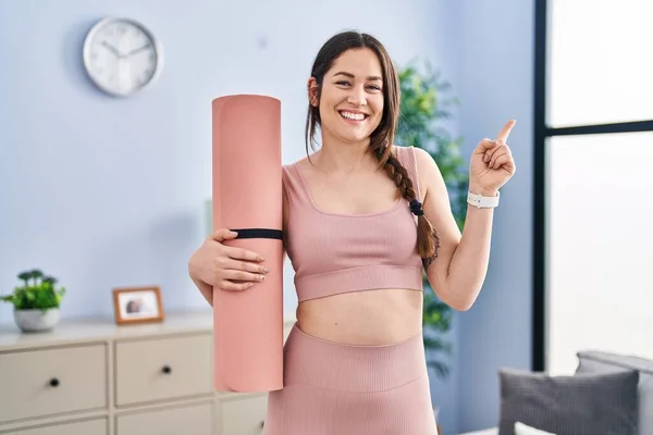 Jong Brunette Vrouw Holding Yoga Mat Glimlachen Gelukkig Wijzend Met — Stockfoto
