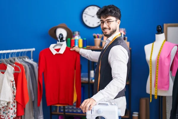 Young Hispanic Man Tailor Smiling Confident Holding Clothes Rack Sewing — Fotografia de Stock