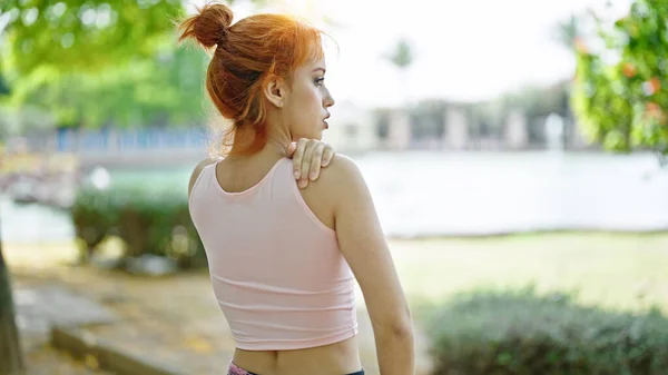 Jonge Roodharige Vrouw Draagt Sportkleding Aanraken Schouder Park — Stockfoto