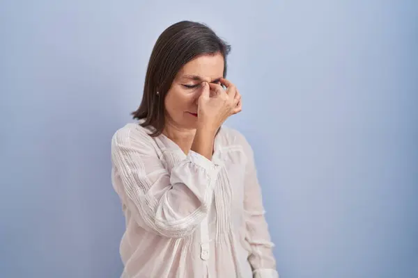 파란색 배경에 히스패닉 피로와 두통을 느끼는 문질러 스트레스와 좌절감 — 스톡 사진