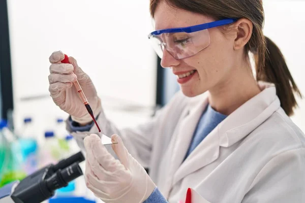若いブロンド女性科学者血を注ぐ上のサンプルで実験室 — ストック写真