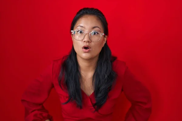 Asyalı Genç Bir Kadın Kırmızı Arka Planda Duruyor Şaşırmış Şaşırmış — Stok fotoğraf