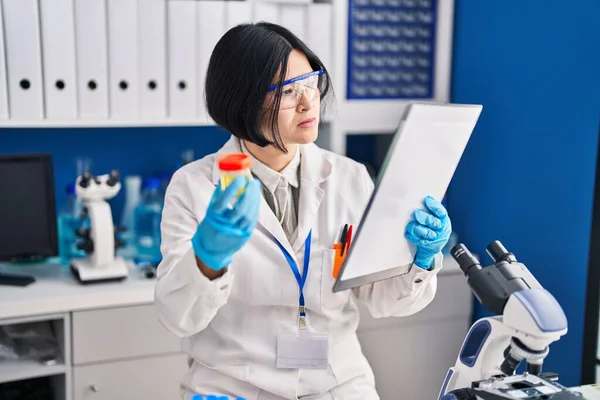Young Chinese Woman Scientist Analysing Urine Reading Report Document Laboratory — ストック写真