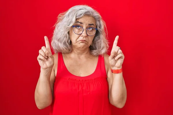 Kırmızı Arka Planda Duran Gri Saçlı Orta Yaşlı Kadın Üzgün — Stok fotoğraf