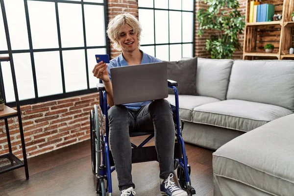 Joven Hombre Rubio Usando Laptop Tarjeta Crédito Sentado Silla Ruedas — Foto de Stock