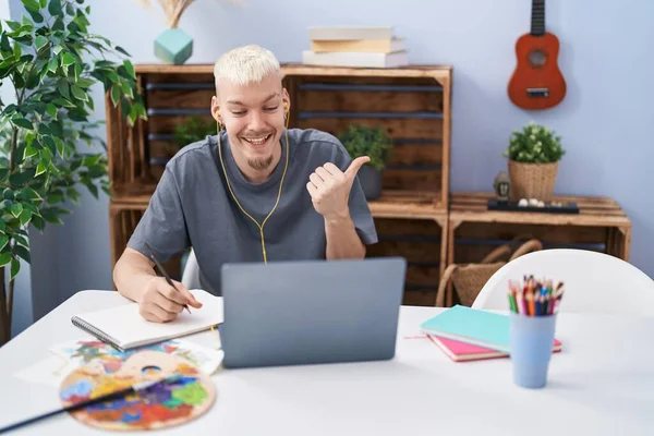 若い慎重な男は ラップトップでビデオ通話を描画し 開いた口で幸せな笑顔に親指を向ける — ストック写真