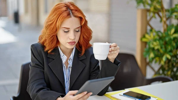 喫茶店のテラスでタッチパッドコーヒーを使用した若い赤毛の女性ビジネスワーカー — ストック写真